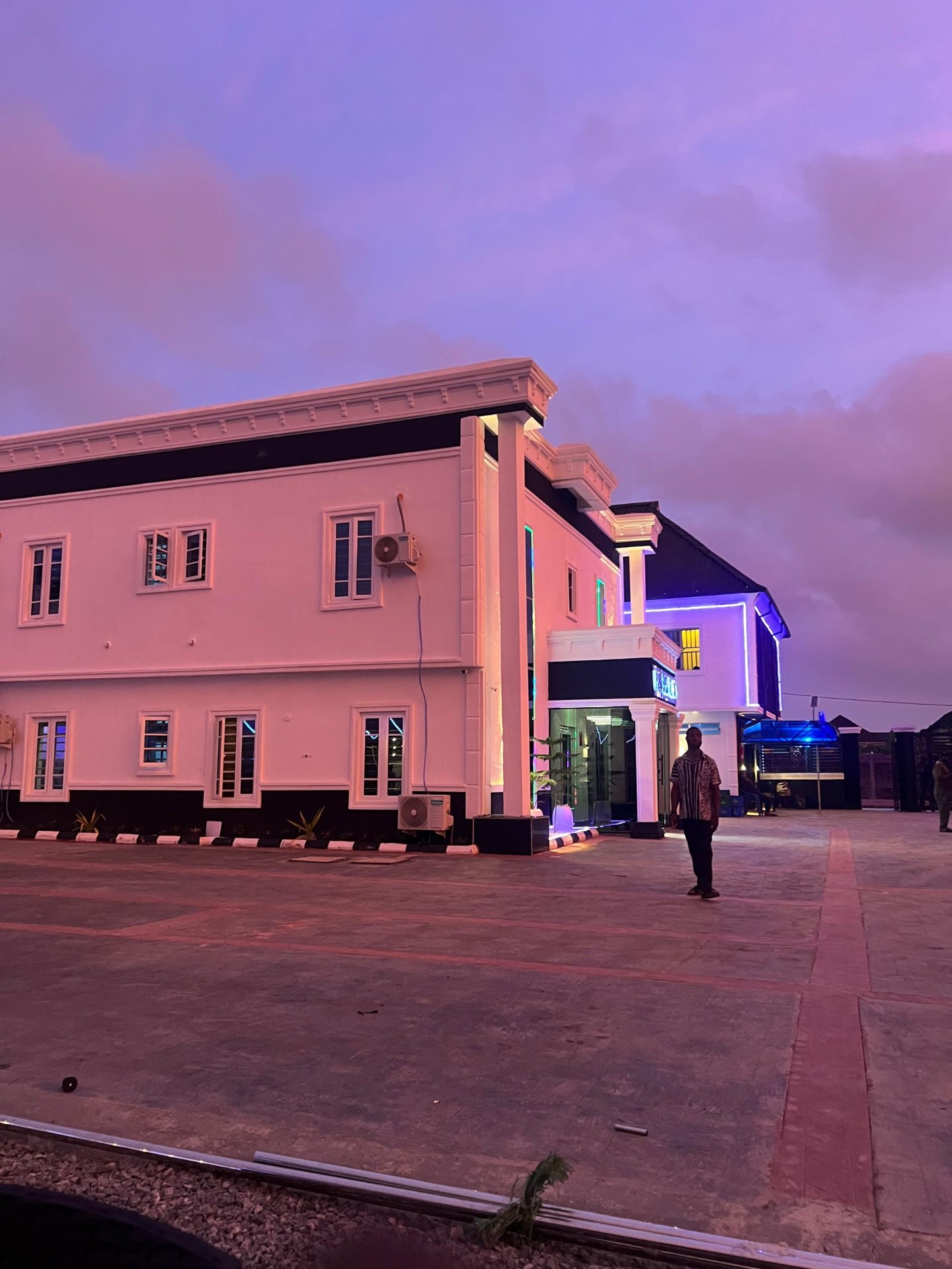 Hotel exterior at twilight with purple sky and neon accents