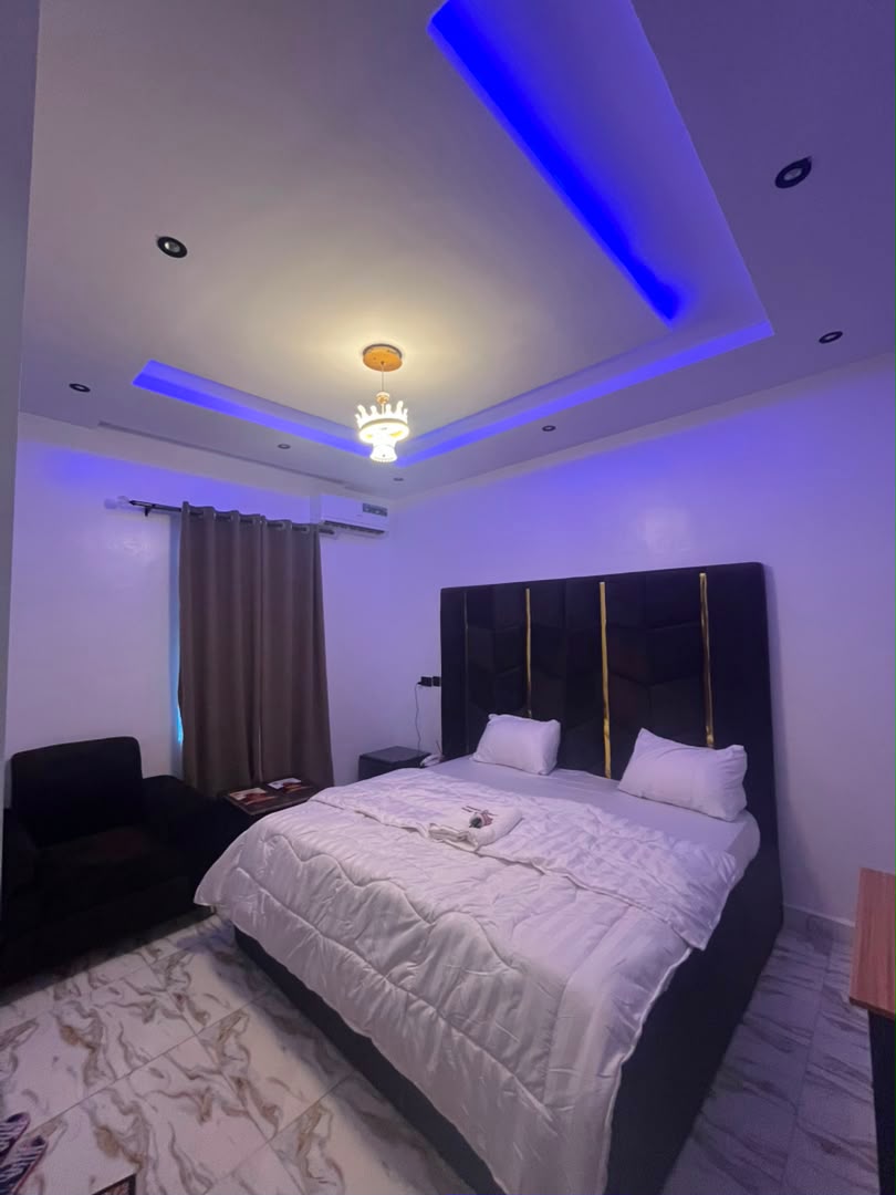 Suite with blue LED cove ceiling and gold-accented headboard