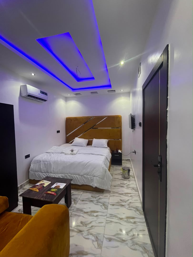 Suite with violet LED ceiling and amber velvet headboard