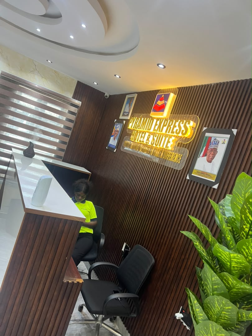 Warm wood-panelled reception with illuminated Pyramid Express signage