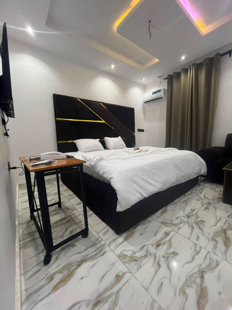 Marble-floored king room with gold-striped headboard